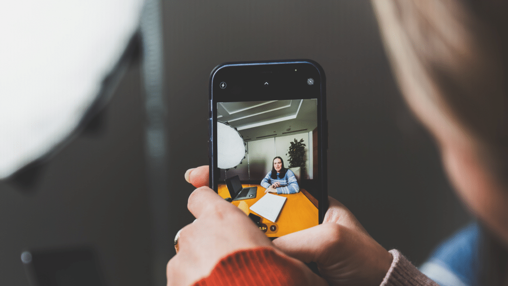 Person using their phone to shoot social media content of a coworker