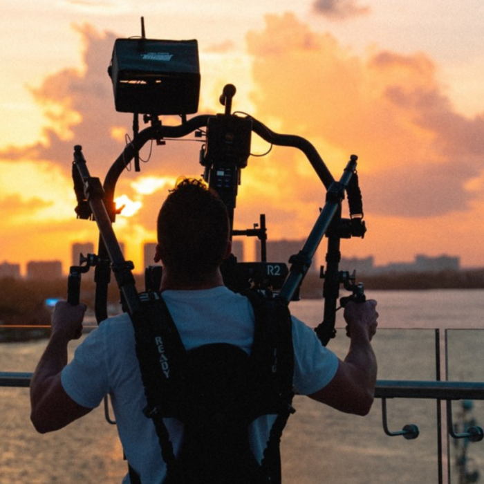 Camera operator catching footage of sunset for a video