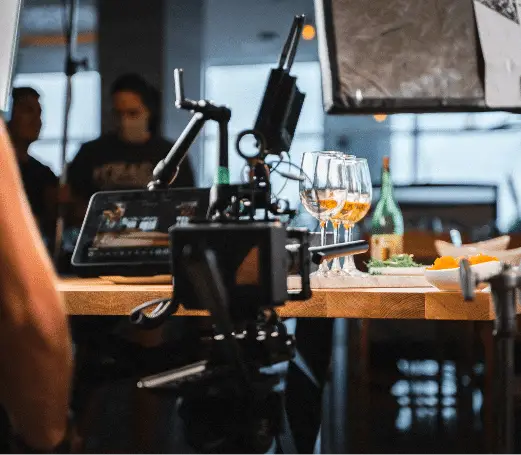 Video production equipment filming wine glasses on a resort restaurant table