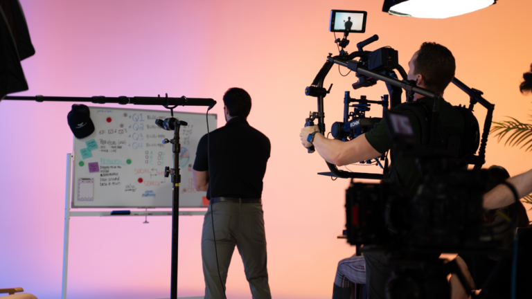 Video production filming a man looking at a white board