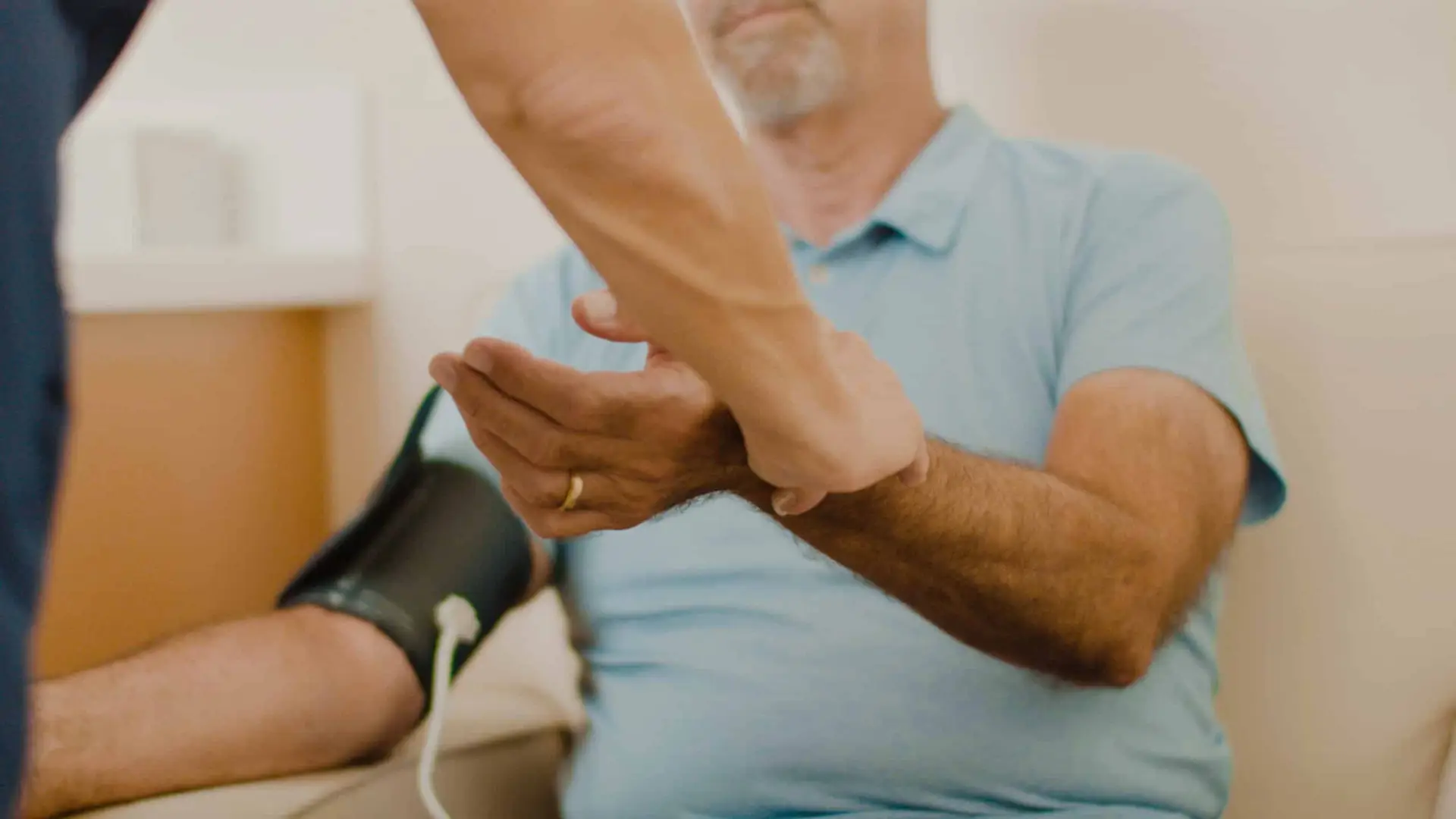 Closeup of a nurse taking a patients' pulse and blood pressure