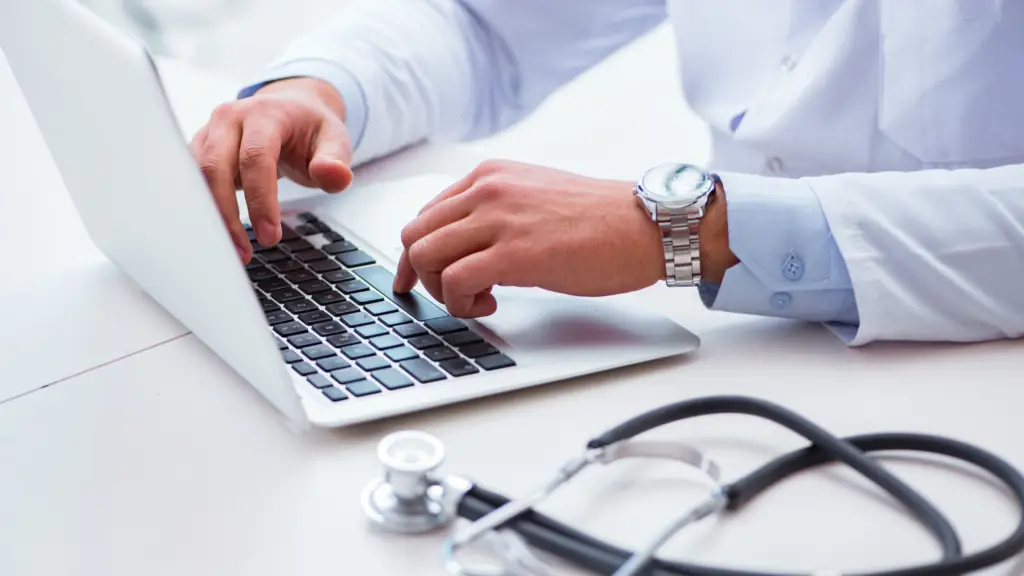 Person in a lab coat using a laptop to created a healthcare marketing email