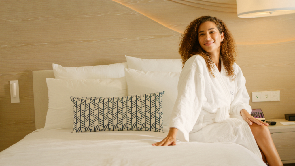 Woman sitting on a hotel room bed at a tourist destination