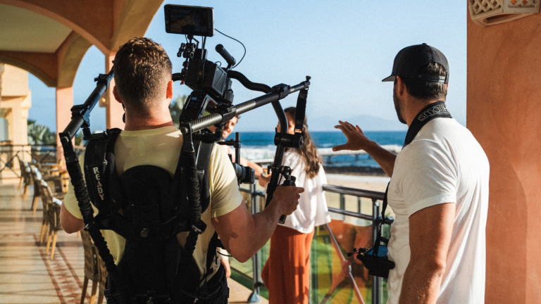 Video production crew filming at a beach resort