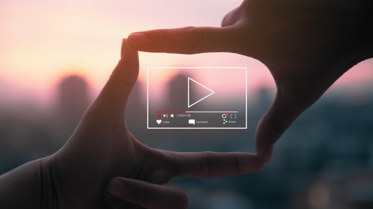 Two hands making a rectangle around a video play button