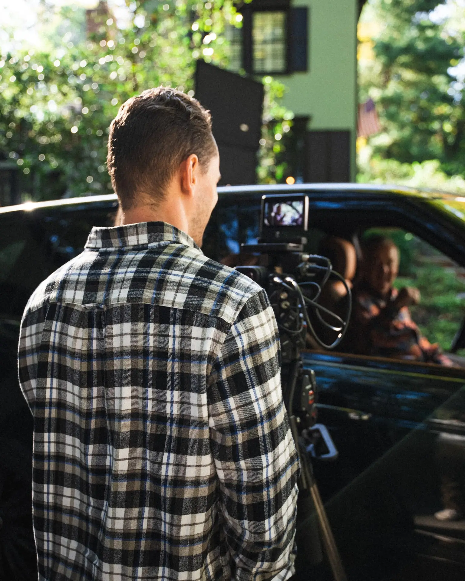 Video production team filming a person in their car
