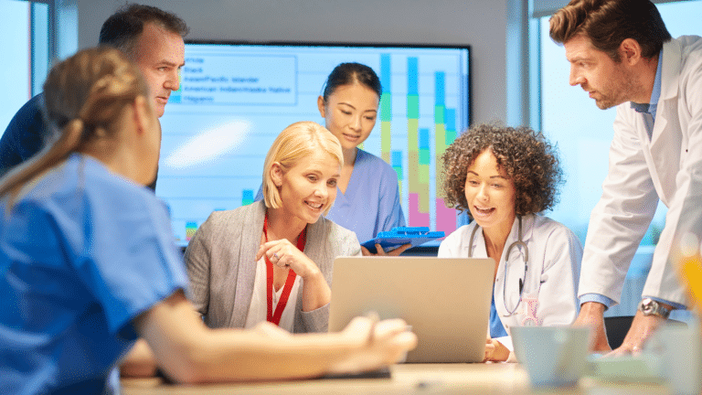 Healthcare marketing team huddled around a laptop