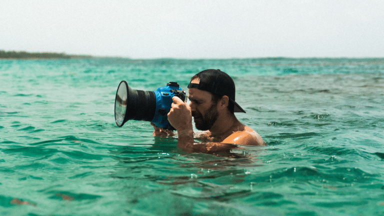 Man in the sea holding a camera for tourism video production