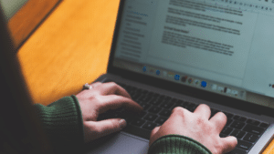 Closeup of hands on a laptop writing copy for a website
