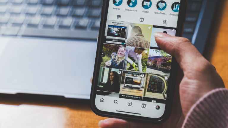 Closeup of a phone showing an Instagram feed with graphics.