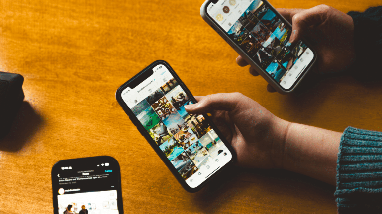 Closeup of three phones with Instagram feeds on the screens