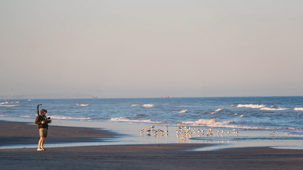 Tourism video crew member filming on the beach