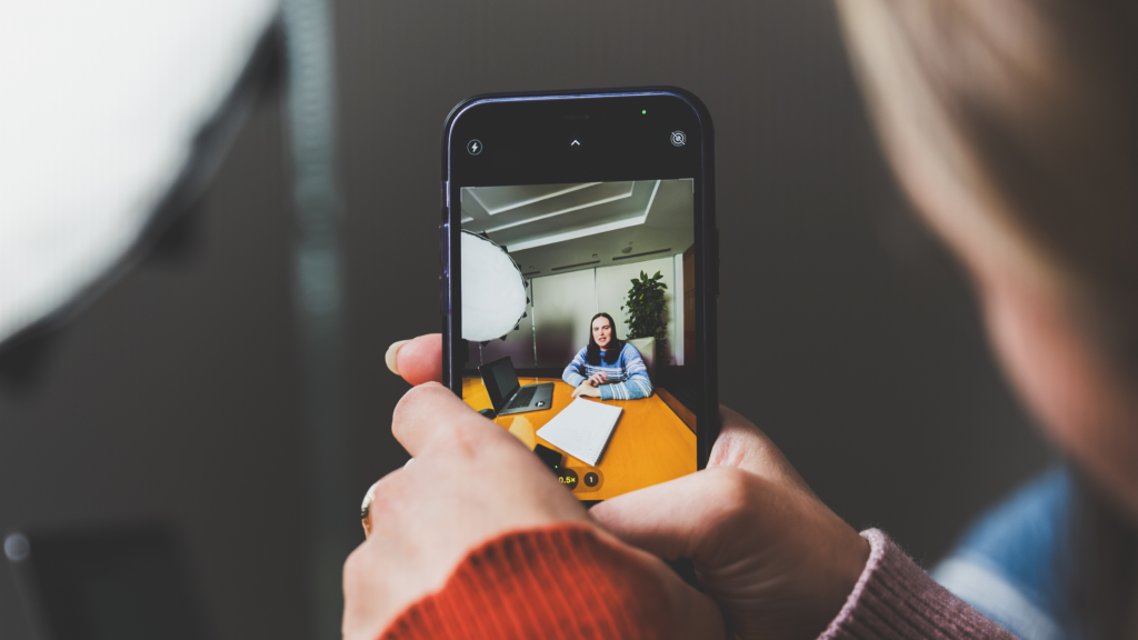 Social media marketer using a phone to record social media content